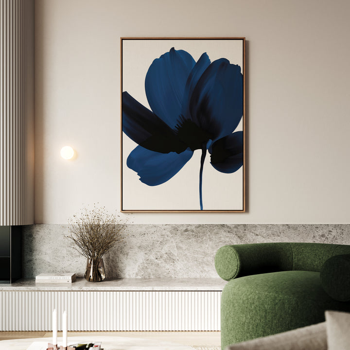 A modern living room features the Nocturne Blossom Canvas Art—a large abstract blue flower painting—paired with a round green sofa, marble accents, a small wall light, and a vase of dried branches on a built-in shelf.