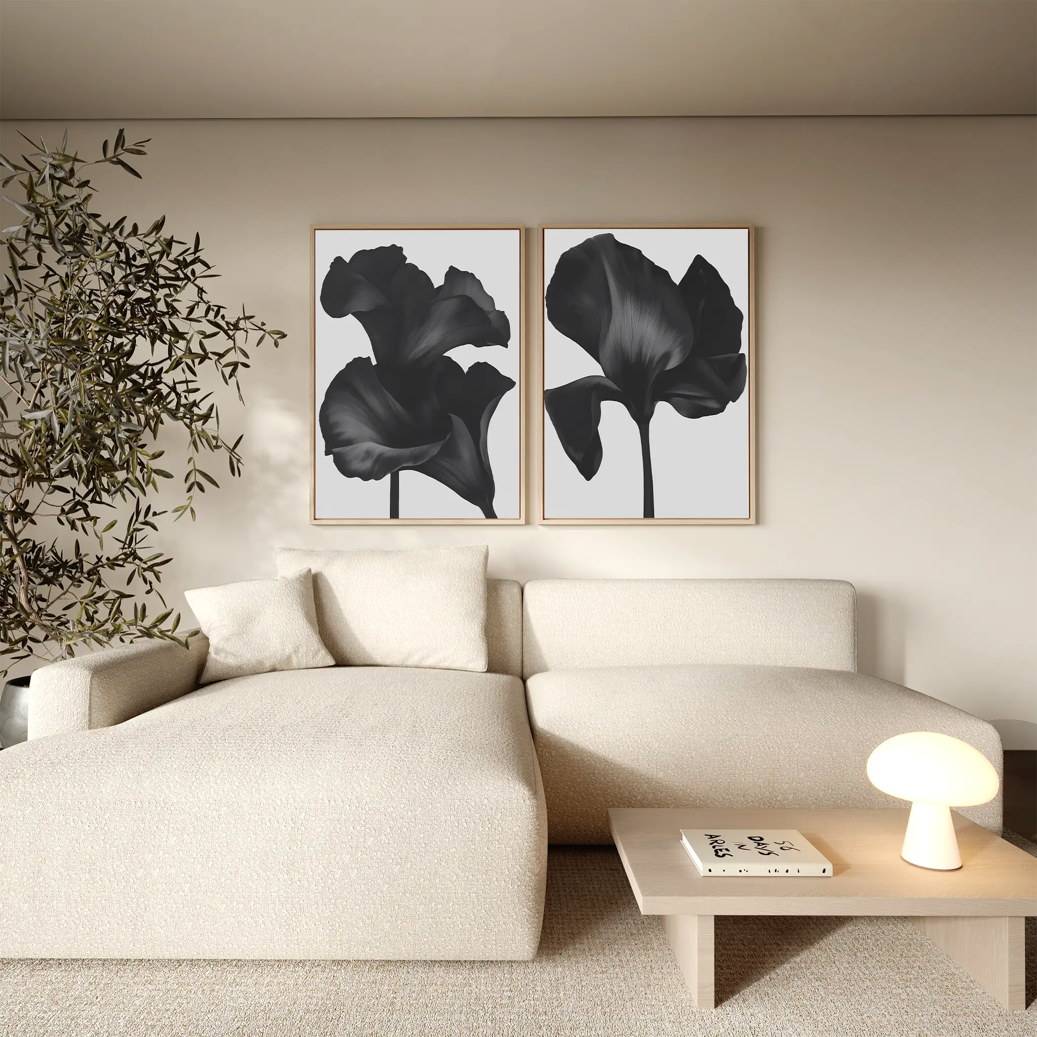 A minimalist living room with a beige sofa, light wooden table, small lamp, potted plant, and the Noir Bloom Set of 2 wall art prints hanging above the sofa.