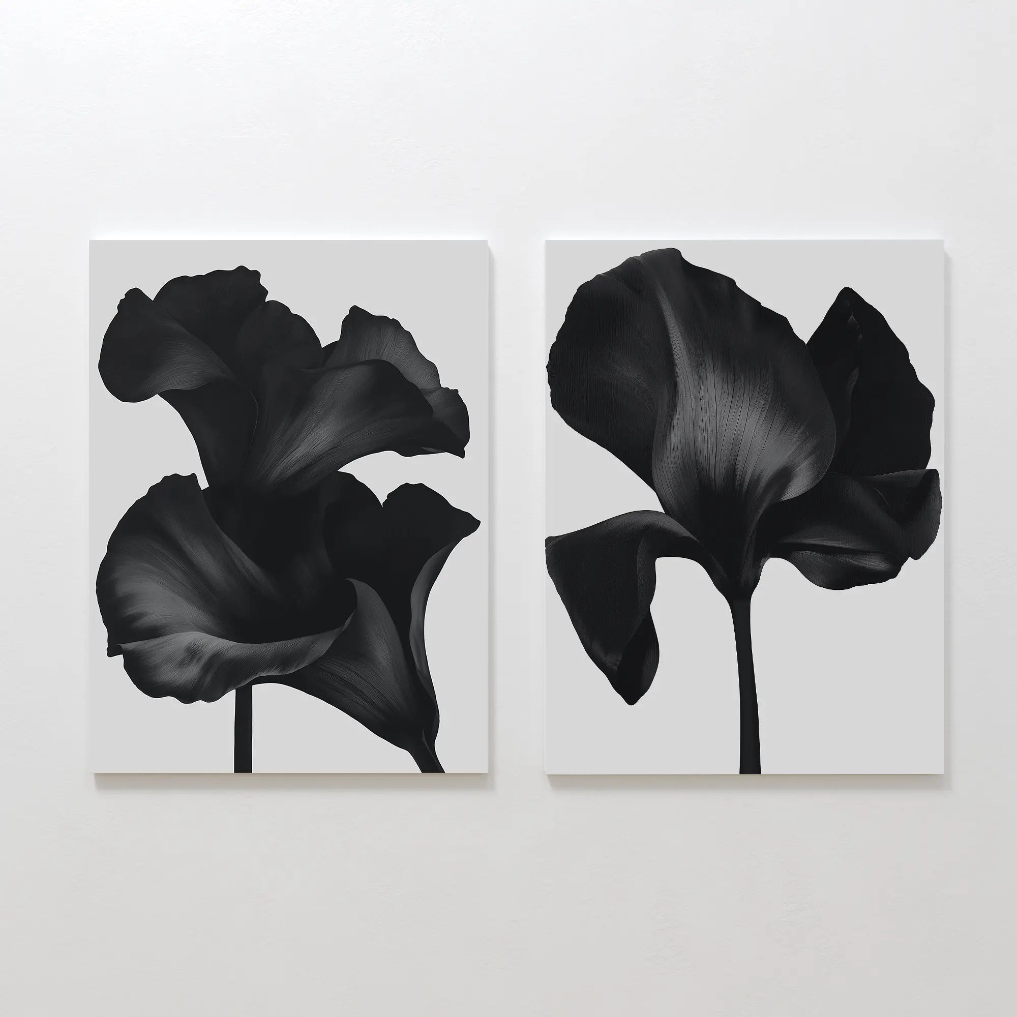 The Noir Bloom Set of 2 features minimalist canvas prints with close-up black iris flowers and soft petals on white backgrounds—perfect contemporary wall art for any space.