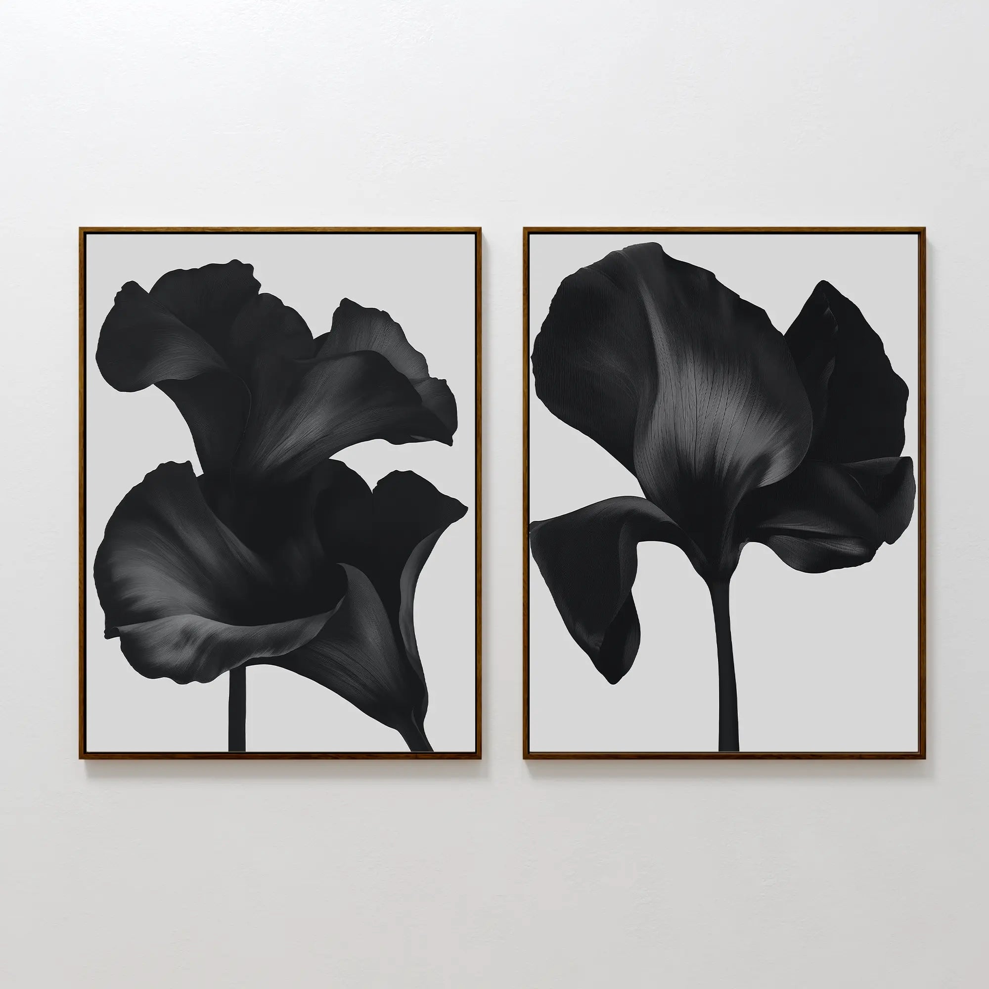The Noir Bloom Set of 2 features framed black floral prints with detailed single blooms on light gray backgrounds, hung side by side—perfect contemporary wall art for any modern space.