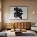 A modern living room with a light sofa, wooden coffee table, textured sideboard, and minimalist decor features the Noir Bloom Canvas Art – Horizontal above the sideboard, enhancing the space with its bold black-and-white floral design.