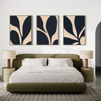 A modern bedroom with an olive green bed, white bedding, two beige nightstands with matching lamps, and the Noir Blossom Set of 3 minimalist black and beige wall art pieces above the bed.