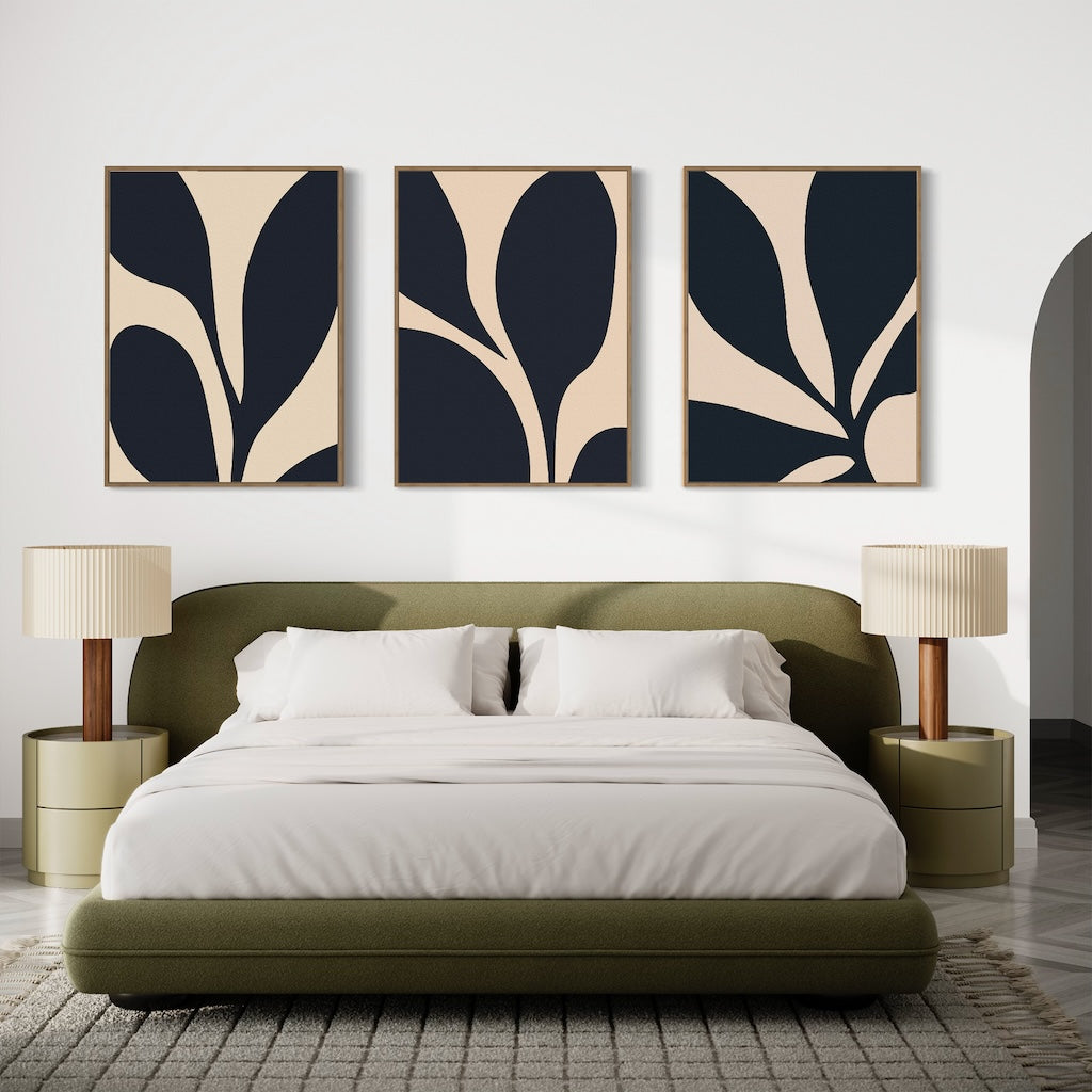 A modern bedroom with an olive green bed, white bedding, two beige nightstands with matching lamps, and the Noir Blossom Set of 3 minimalist black and beige wall art pieces above the bed.