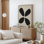 A modern living room with light wood furniture, a white sofa, a round coffee table, and the Noir Botanica Canvas Art above the sideboard. A potted plant and neutral-toned decor complete the sophisticated look.