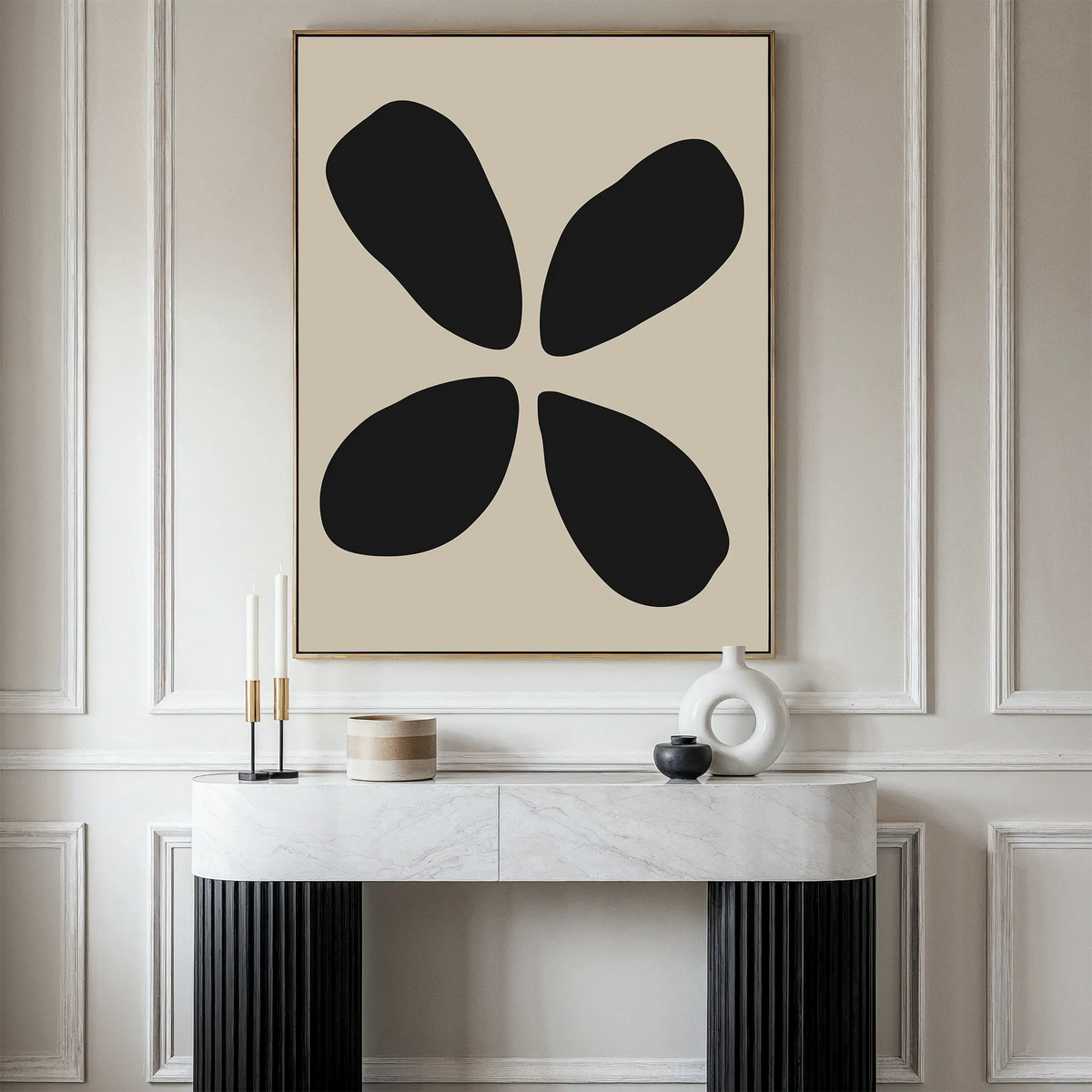 A modern living space featuring the Noir Botanica Canvas Art—a large abstract piece with four black shapes on a beige background—hung above a white console table decorated with candles, a vase, and modern decor.