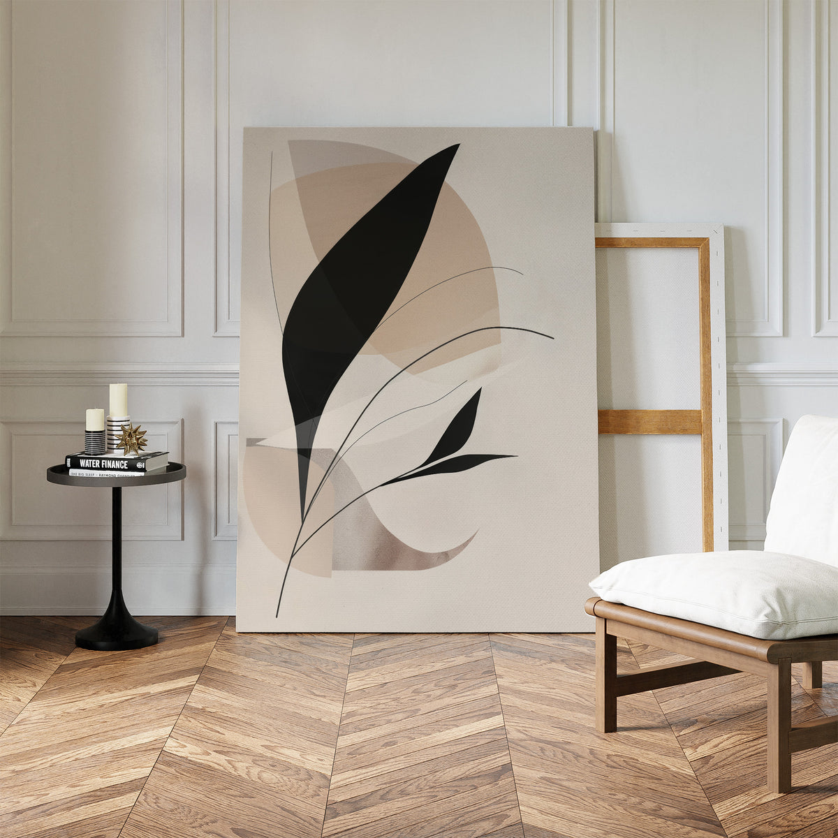A minimalist room with herringbone wood floors, a white cushioned chair, a black side table with candles and books, and the Noir Petals in Motion Abstract Canvas Art leaning against a white-paneled wall for a modern touch.