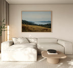 A modern living room featuring a light beige sectional sofa, low wooden coffee table, tall plant, and the Northern Silence Canvas Art as minimalist wall art on a neutral wall for an elegant decor touch.