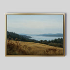 The Northern Silence Canvas Art features a serene landscape with grassy fields, rolling hills, calm water, and distant blue mountains—ideal minimalist wall art to enhance your living room decor.