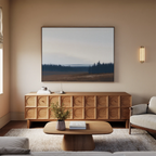 A cozy living room with a modern wooden sideboard, minimalist coffee table, light sofa, beige walls, and the Northern Woods Canvas Art above the sideboard. A small vase with flowers sits on the table.