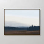 The Northern Woods Canvas Art features a framed minimalist painting of a flat brown field and distant dark trees beneath a pale, cloudy sky, evoking the tranquil beauty of a Nordic park.
