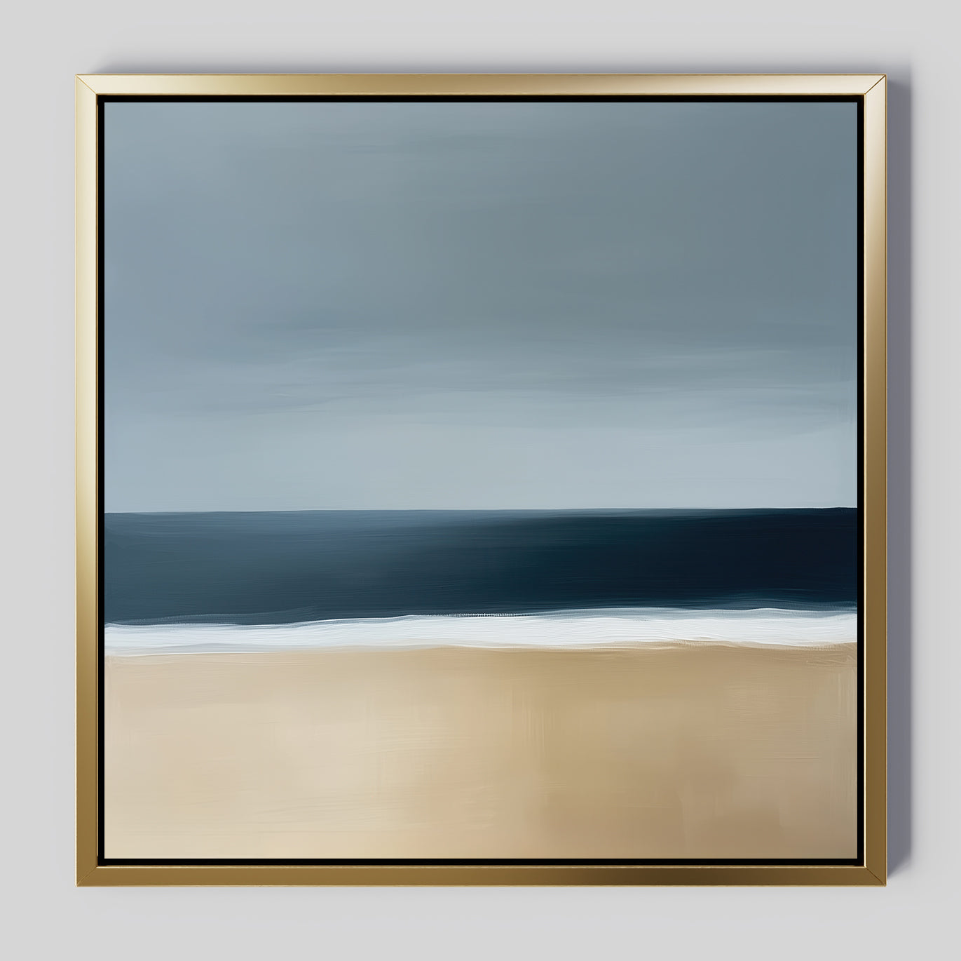 Ocean Edge Canvas Art features minimalist coastal wall art with a sandy beach, dark blue sea, and cloudy sky in soft, blended tones. Elegantly presented in a sleek gold frame for a modern touch.