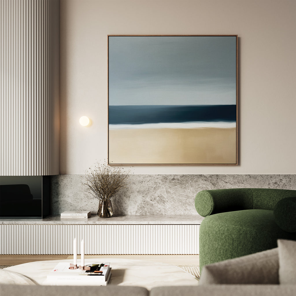 A modern living room with a green armchair, marble surfaces, a minimalist wall light, a vase of dried branches, and Ocean Edge Canvas Art—a striking large abstract beach scene—displayed on the wall.