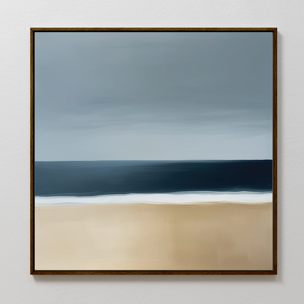 Ocean Edge Canvas Art showcases minimalist coastal style with soft sandy hues, a dark blue ocean band, and a gradient gray-blue sky in a simple dark wood frame—perfect for adding serene beach vibes to any space.