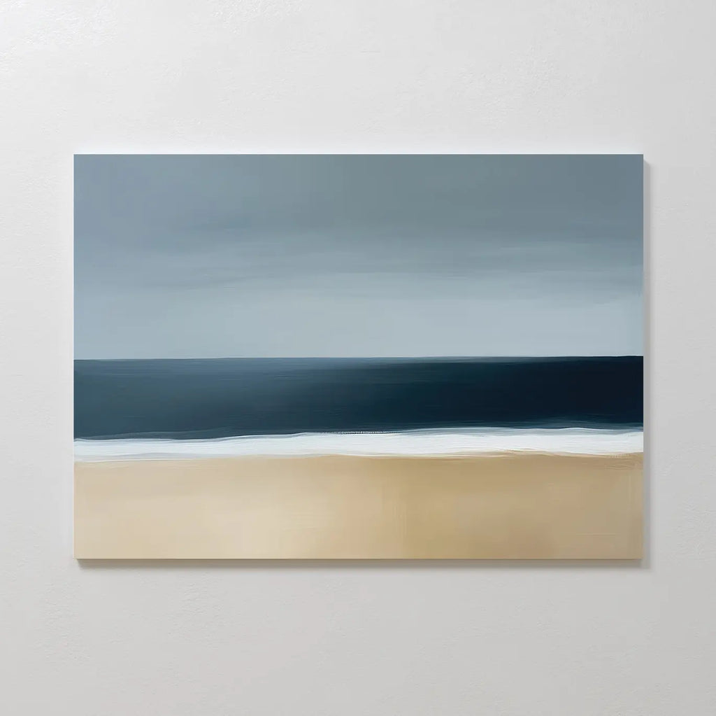 The Ocean Edge Canvas Art – Horizontal is a minimalist abstract piece with soft brushstrokes, depicting a sandy beach, white surf, and deep blue ocean under a cloudy gray sky.