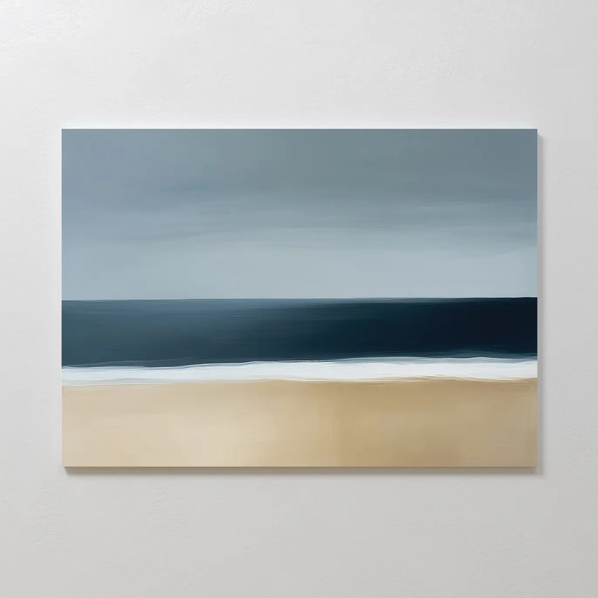 The Ocean Edge Canvas Art – Horizontal is a minimalist abstract piece with soft brushstrokes, depicting a sandy beach, white surf, and deep blue ocean under a cloudy gray sky.