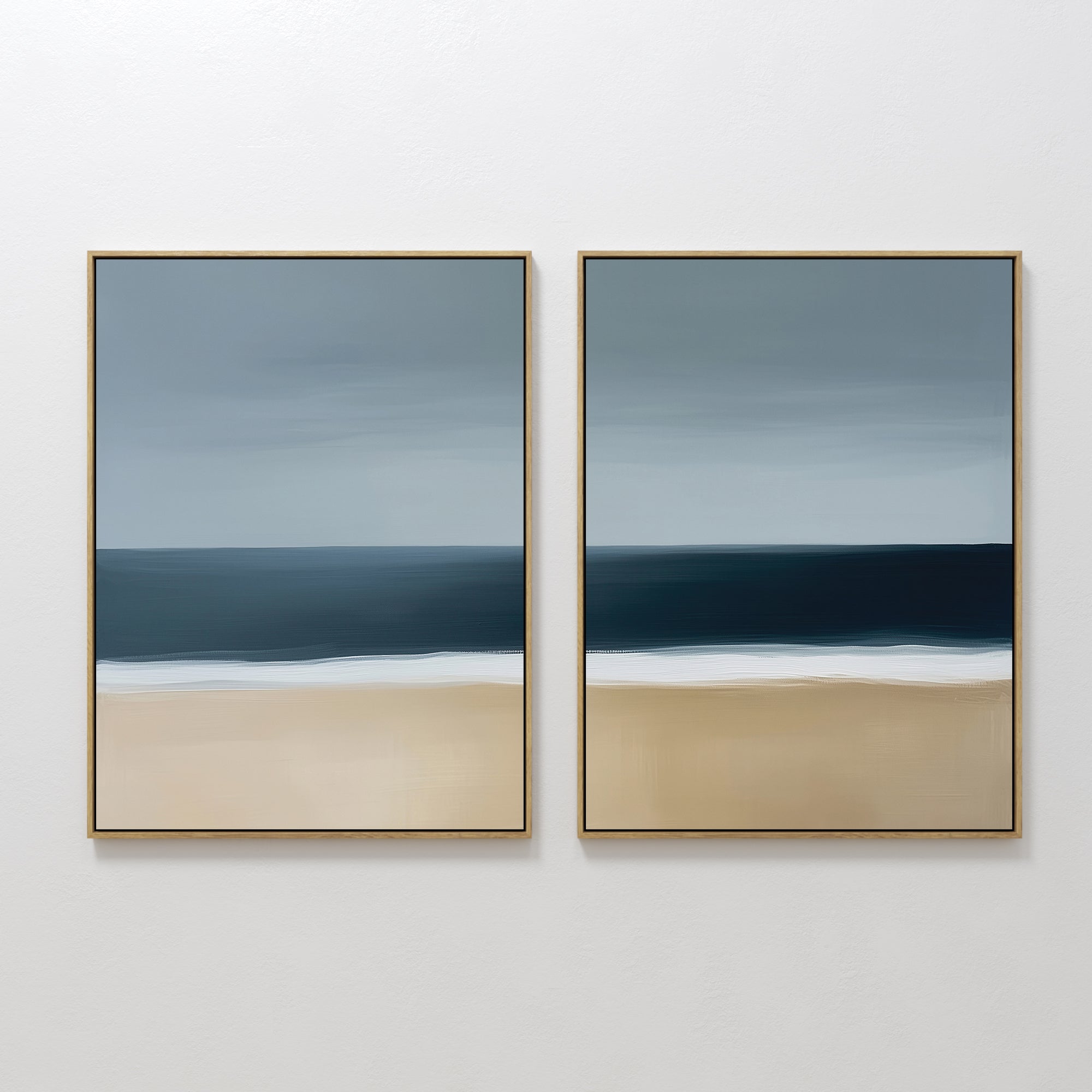 The Ocean Edge Set of 2 features framed abstract wall art with muted beige sand, deep blue water, and a gradient sky, creating a serene beach scene—perfect coastal decor for your living room.