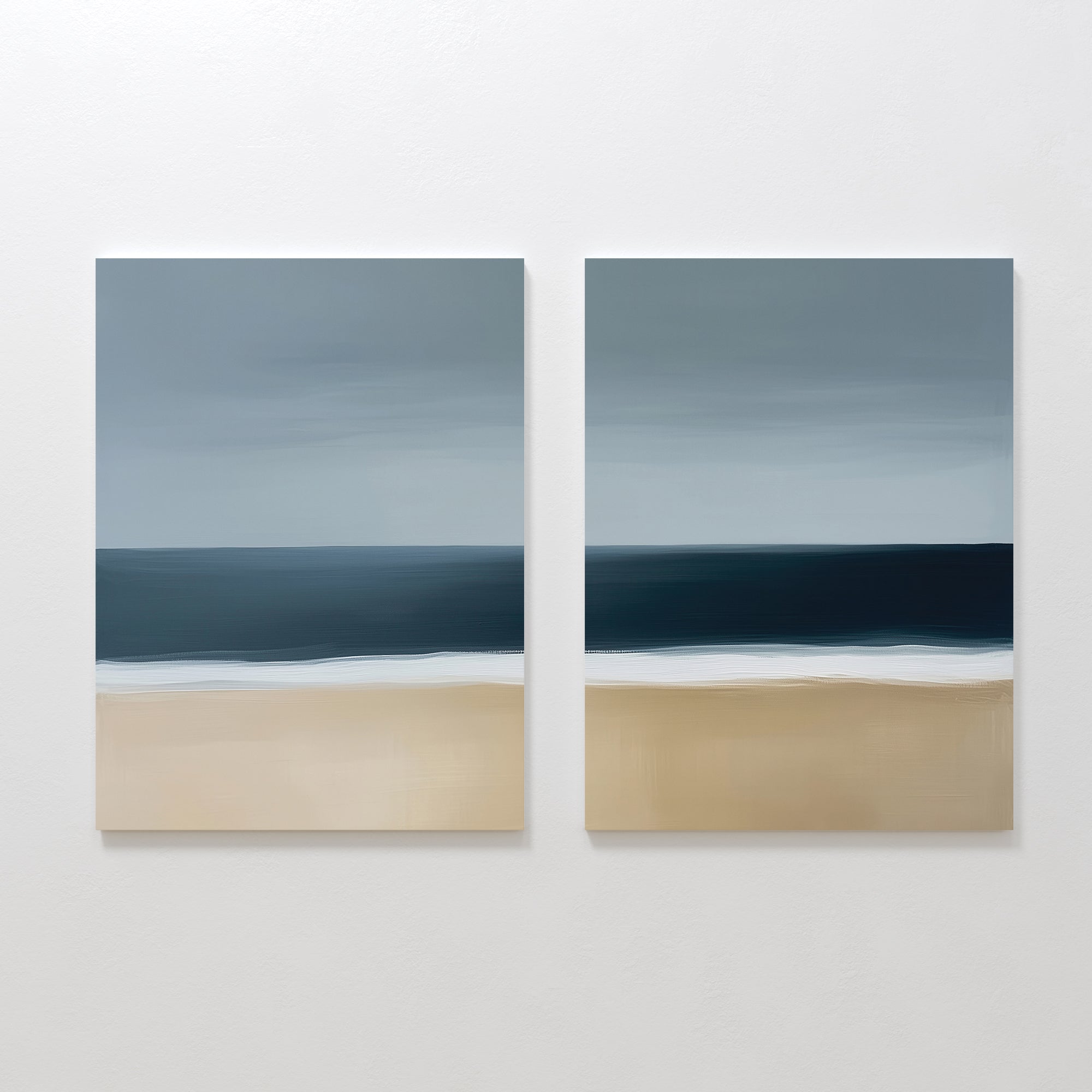 The Ocean Edge Set of 2 features square paintings with a minimalistic seascape—sandy beach, deep blue ocean, and cloudy sky in soft brushstrokes—perfect for serene coastal decor in your living room.