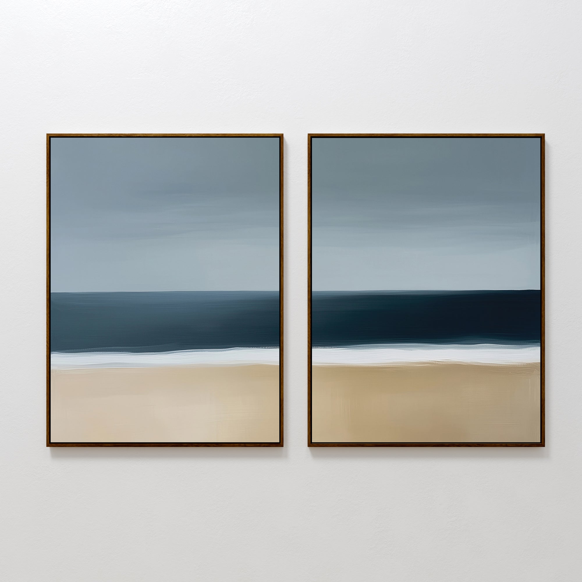 The Ocean Edge Set of 2 features framed abstract paintings in soft blue, gray, and beige, capturing the sky, sea, and beach for calming coastal wall art—ideal for serene living room decor.