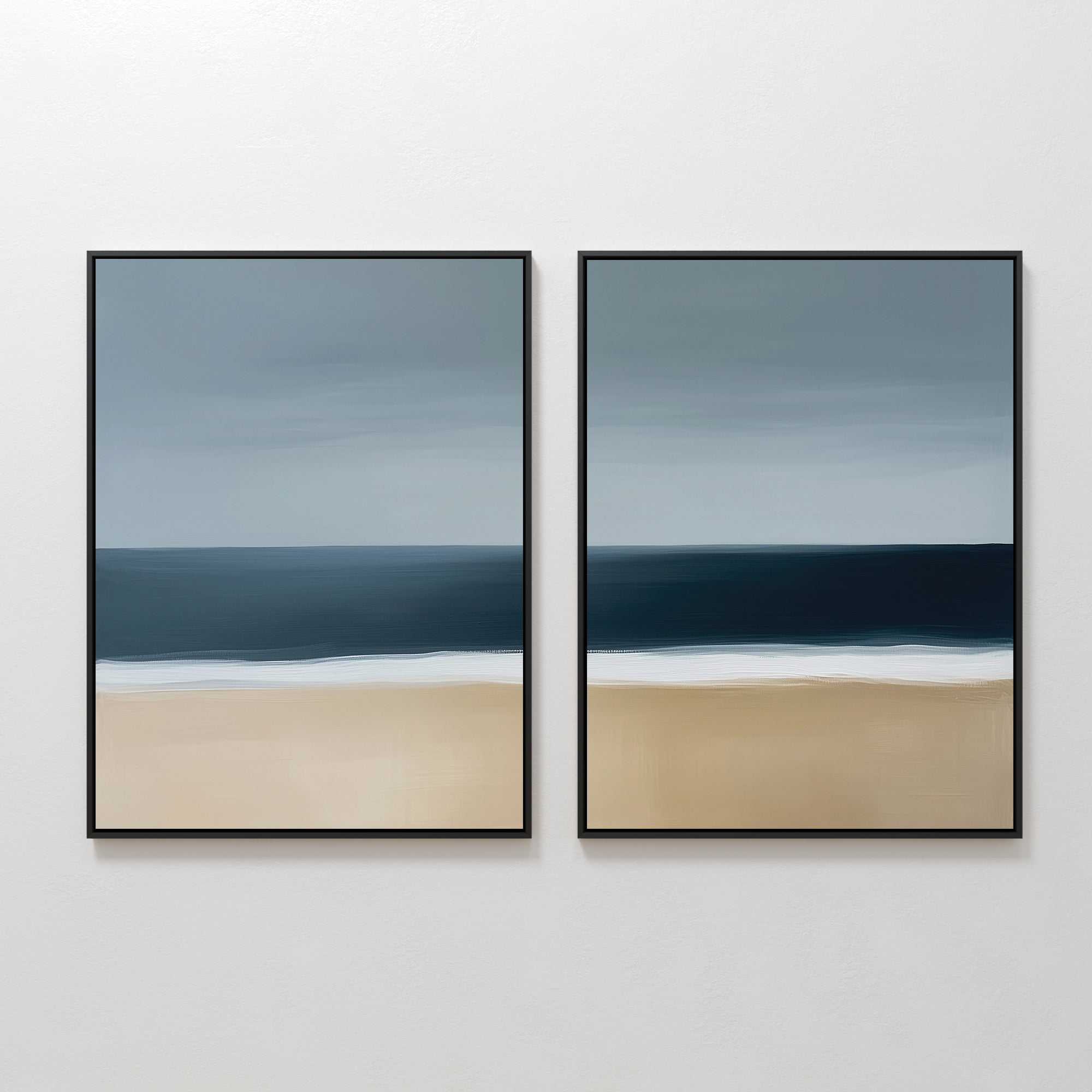 The Ocean Edge Set of 2 features minimalist abstract paintings of a blue sky, deep ocean, white surf, and sandy beach—ideal coastal wall art to elevate your living room decor on a plain white wall.