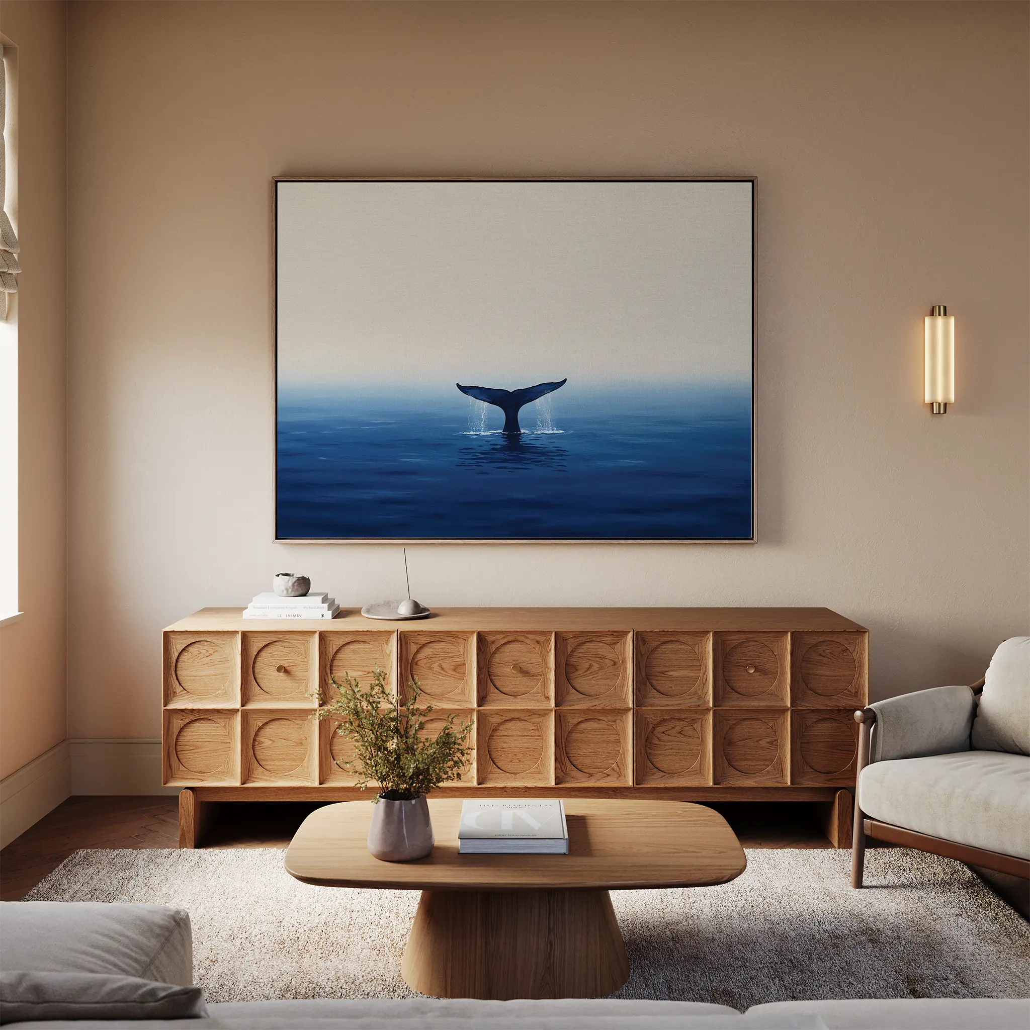 A cozy living room features a light sofa, wooden furniture, and the Ocean Giant Canvas Art above a textured wooden sideboard. A small table with books and a vase adds to the room’s relaxed coastal vibe.