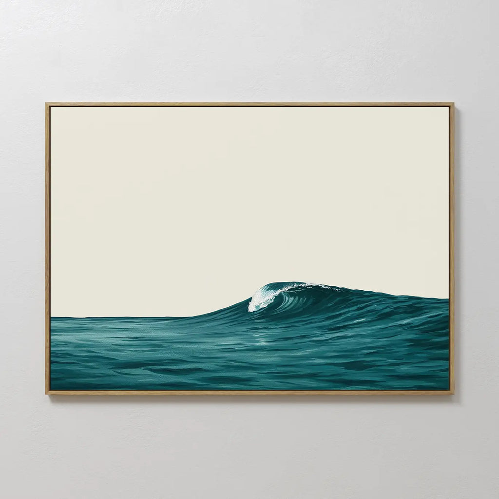 The Oceanside Crest Canvas Art, featuring a deep blue ocean wave and a light sky, hangs on a plain white wall—ideal minimalist wall art for modern bedroom decor.