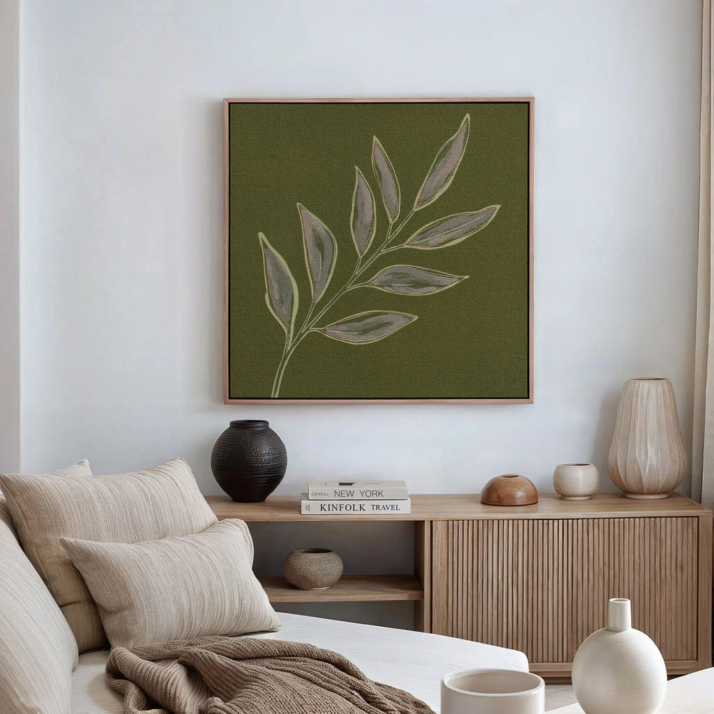 A modern living room featuring a neutral-toned sofa, striped cushions, a wooden sideboard with decor, and the Olive Branch Canvas Art above the sofa for an elegant botanical touch to your modern space.