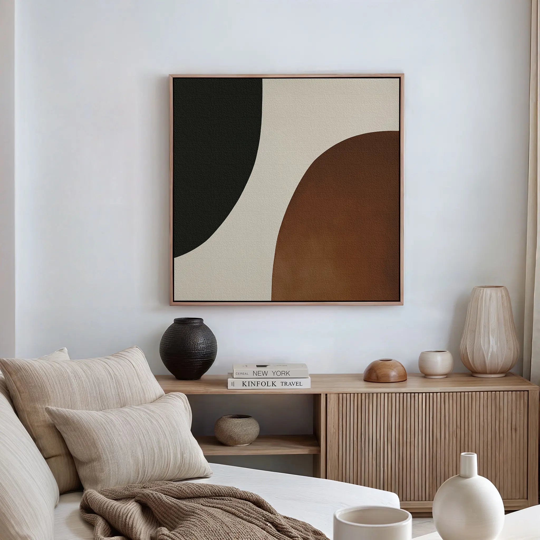 A modern living room with a beige sofa, striped pillows, a wooden sideboard with neutral decor, and the Organic Balance Canvas Art—modern abstract wall art in black, cream, and brown—perfect for minimalist living room style.