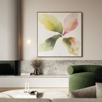 A modern living room with a green armchair, minimalist decor, and the Petal Hues Canvas Art—a large wall print featuring an abstract floral design in pastel green and pink leaves—displayed above a marble surface.