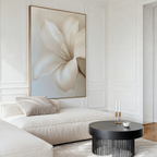 A modern living room featuring cream-colored furniture, the Pure Magnolia Canvas Art as minimalist wall decor, a round black coffee table, and gentle natural light.