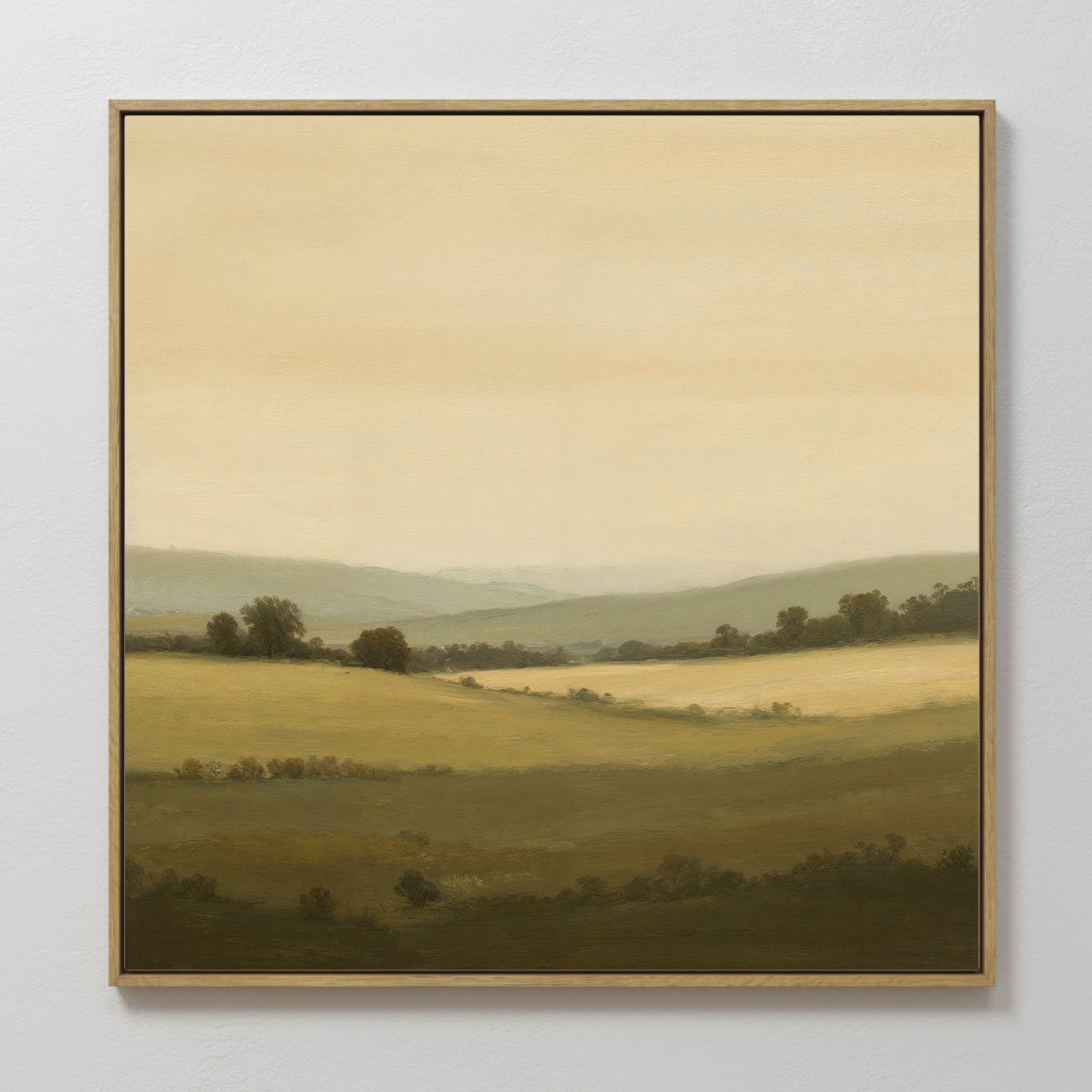 Quiet Countryside Canvas Art: A framed painting depicting rolling green hills, scattered trees, and a soft, hazy sky in warm tones. This serene rural landscape creates a peaceful and calming atmosphere for any room.