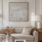 A modern living room featuring a beige sofa, neutral pillows, a wooden side table with a ceramic lamp, and Quiet Structure Canvas Art in soft tones. A vase with dried flowers on the coffee table completes the minimalist decor.