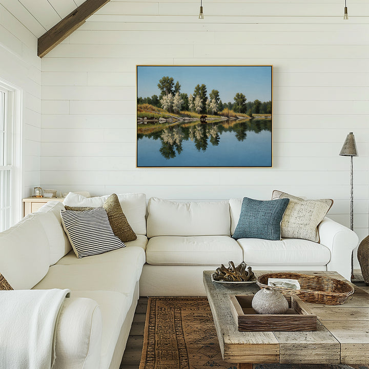 A bright, cozy living room with a white sectional sofa, patterned pillows, wooden coffee table, and minimalist decor—featuring the Reflections of the Wild Canvas Art on a white shiplap wall—glows with natural light.