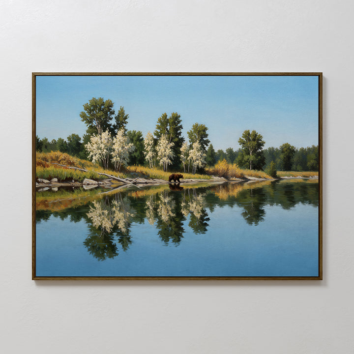 Reflections of the Wild Canvas Art features a peaceful river mirroring tall green and white trees under a blue sky, with a brown bear at the waters edge—perfect wall art for any nature-inspired space.