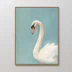 The Regal Swan Canvas Art is a minimalist piece featuring a white swan with an orange beak on a soft blue background, in a gentle painterly style. The swan faces left and the artwork comes framed, perfect for displaying on a white wall.