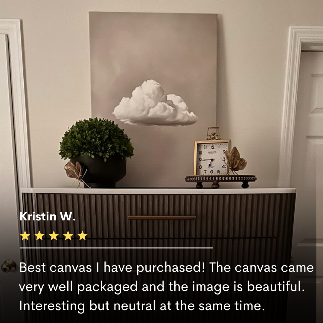 The Morning Sky Abstract Canvas Art, featuring minimalist white clouds, hangs above a striped dresser adorned with a clock, potted plant, and decor. A 5-star review highlights the artwork’s serene touch to the space at the bottom.