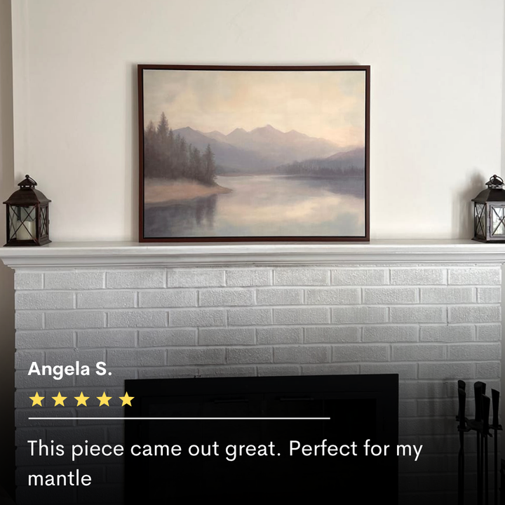 The Smoky Peaks Canvas Art hangs above a white brick mantle, flanked by two vintage lanterns. A black fireplace sits below. Text reads: “This piece came out great. Perfect for my mantle.”.