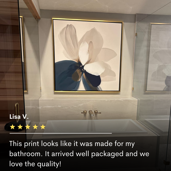 The Whispering Petals Canvas Art in neutral tones hangs above a modern bathtub with gold fixtures in a tiled bathroom, with a five-star customer review displayed below.