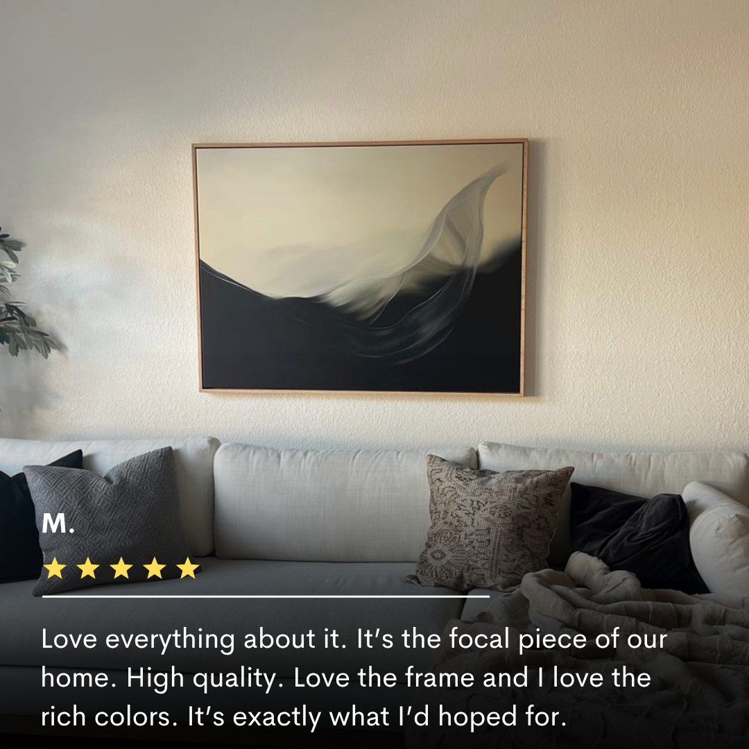 The Oceanic Pulse Abstract Canvas Art, with flowing black and cream tones, hangs above a light gray couch. Natural light enhances the calm, modern decor. Text overlay features a five-star review for this minimalist wall art.