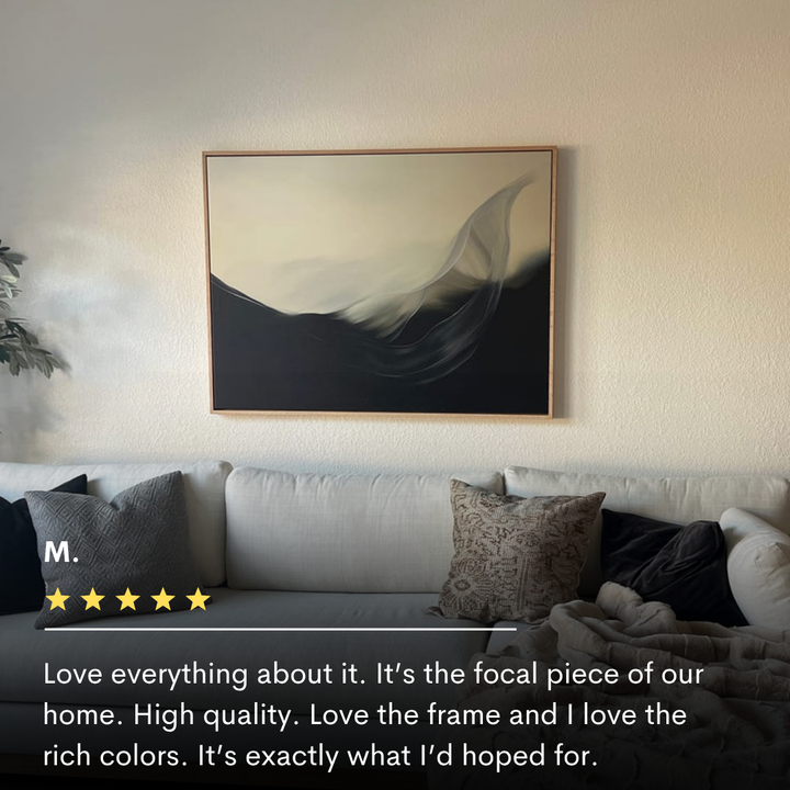 The Oceanic Pulse Abstract Canvas Art, with flowing black and cream tones, hangs above a light gray couch. Natural light enhances the calm, modern decor. Text overlay features a five-star review for this minimalist wall art.
