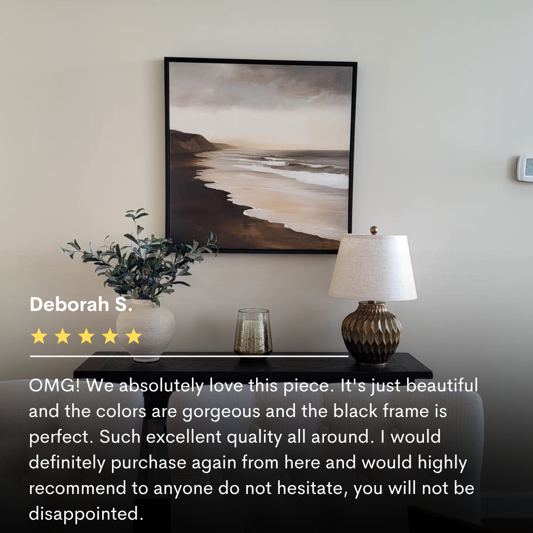 The Sandy Shoreline Canvas Art hangs above a console table with a plant, lamp, and glass candle holder. In the foreground, a five-star review highlights this coastal wall art as perfect living room decor.