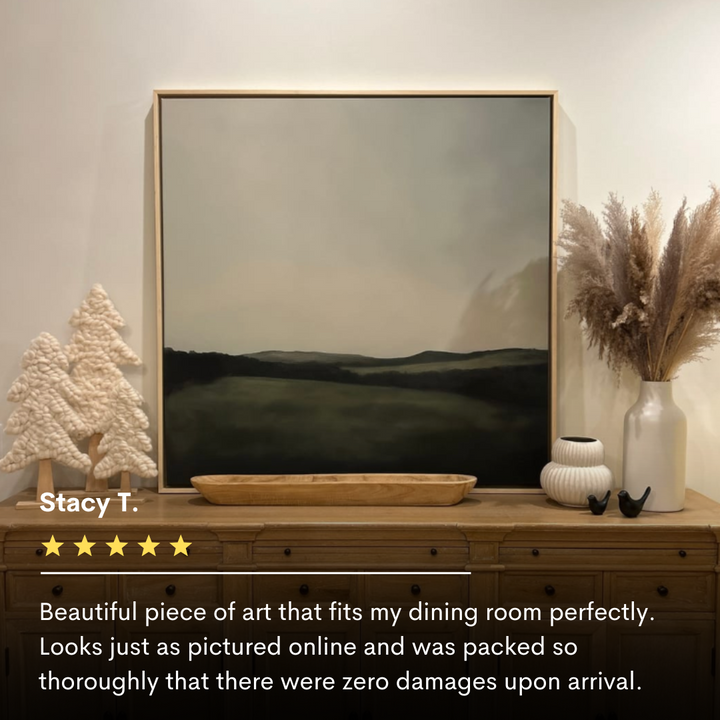 The Hills at Dusk Canvas Art is displayed on a wooden sideboard with neutral decor—vases, a white textured tree, dried pampas grass, and a wooden tray. A five-star review praising the canvas art appears below.