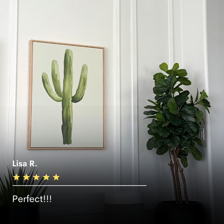 Desert Cactus Canvas Art hangs on a white wall beside a tall potted plant. Lisa R.’s five-star review reads, “Perfect!!!” in white text—an ideal accent for fans of minimalist decor.