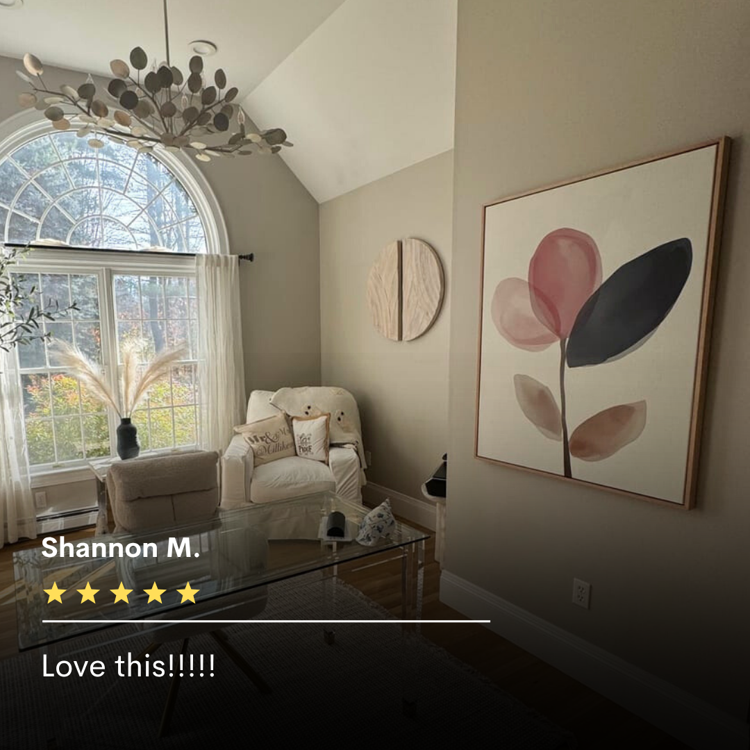 A cozy, sunlit sitting room with a high ceiling, large arched window, white armchair, pampas grass in a vase, modern chandelier, and Petal Breeze Canvas Art creates stunning living room decor. A five-star review is overlaid at the bottom.