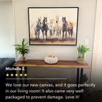 The Sunset Ride Canvas Art hangs above a wooden console table with plants and decor. Michelle Z. praises this horse-themed artwork for fitting perfectly as living room decor and arriving safely thanks to careful packaging.