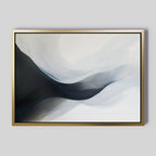 Rippling Vista Abstract Canvas Art features flowing black, gray, and white shapes on a light background in a gold frame. This minimalist piece adds modern elegance to pale gray walls.