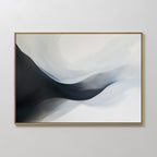 Rippling Vista Abstract Canvas Art features flowing black, gray, and white shapes for a modern, minimalist look. Framed with a thin gold edge and displayed on a light wall, it adds elegant movement to your decor.