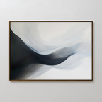 Rippling Vista Abstract Canvas Art features smooth, flowing shapes in black, gray, and white, evoking misty waves or mountains. This minimalist piece comes framed in a thin, dark frame and is ideal for display on a plain white wall.