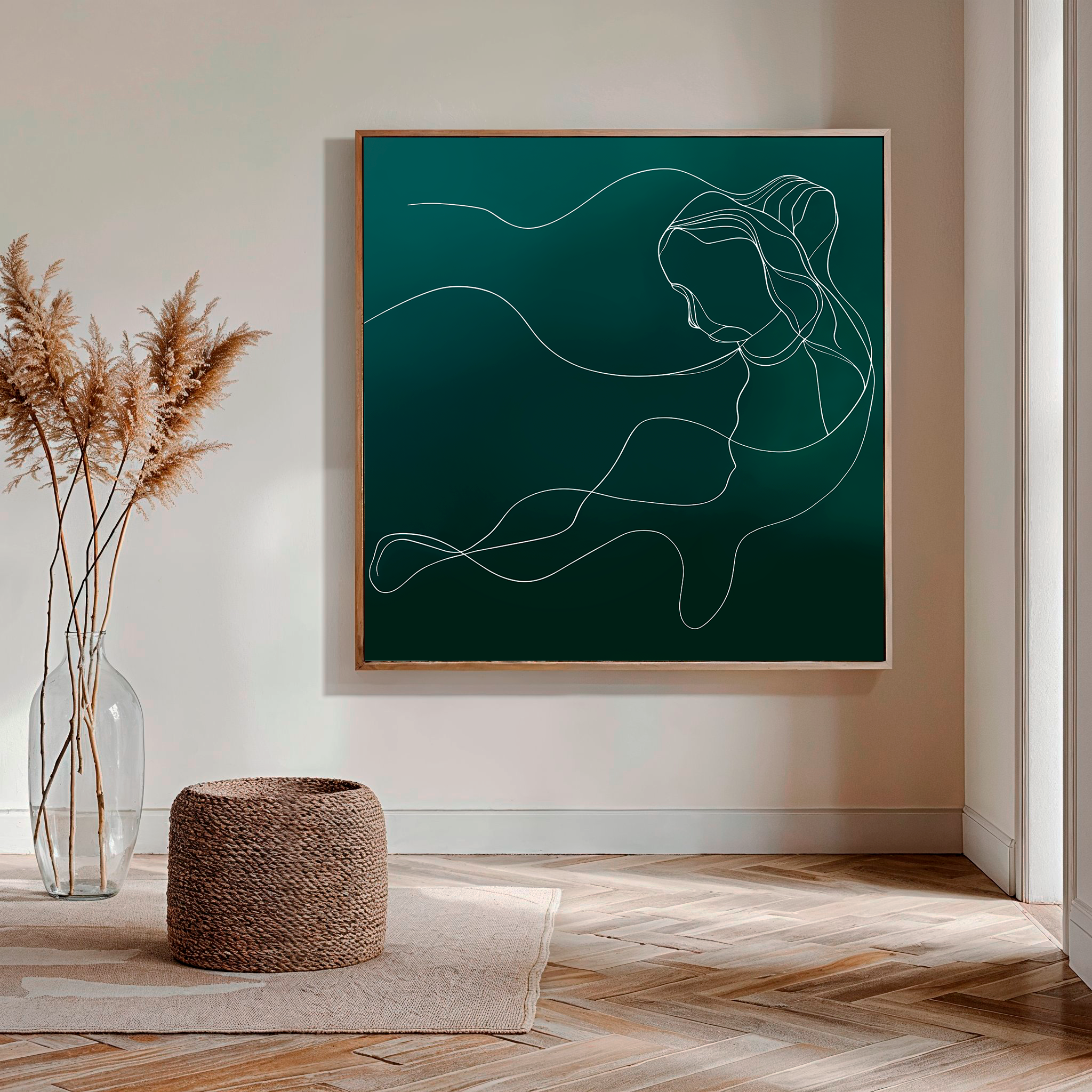 A minimalistic living room decor features the Azure Silhouette Abstract Canvas Art, a glass vase with dried pampas grass, a woven round ottoman, and a rug on wooden herringbone flooring.