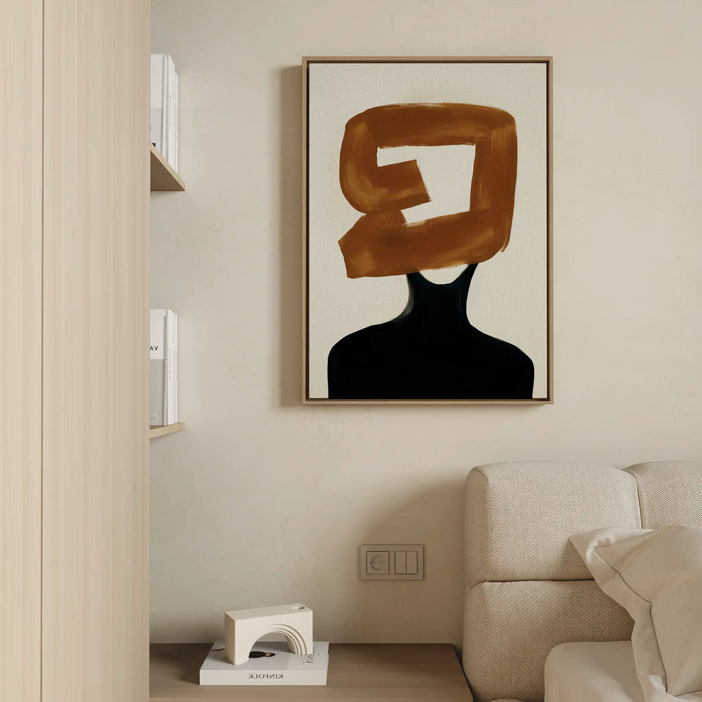 Minimalist living room with a beige sofa, wooden shelving, and Rustic Persona Canvas Art—abstract wall art featuring a modern black silhouette and bold brown brushstroke on a minimalist canvas.