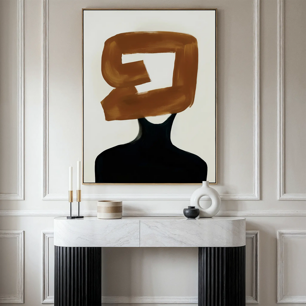 A modern interior showcases a marble console table with candles and decor against a paneled wall. Above the table, the Rustic Persona Canvas Art is displayed, featuring a silhouetted figure with a bold brown brushstroke over the head.